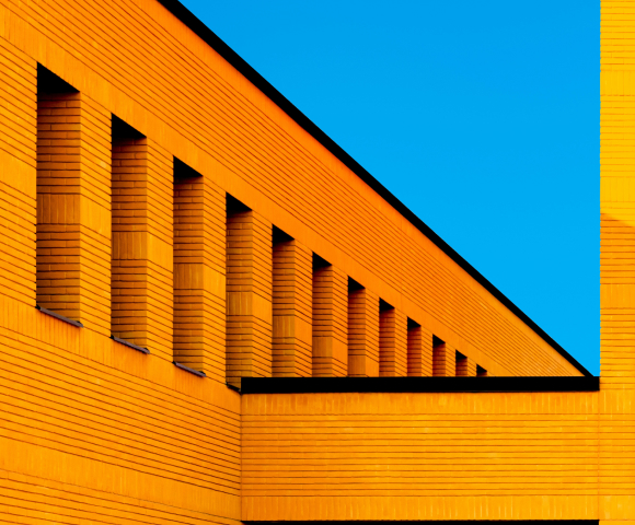 Fachada de un edificio naranja bajo un cielo azul