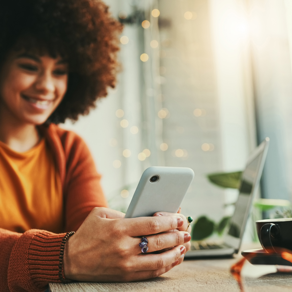 Mujer consultando su teléfono móvil en la oficina