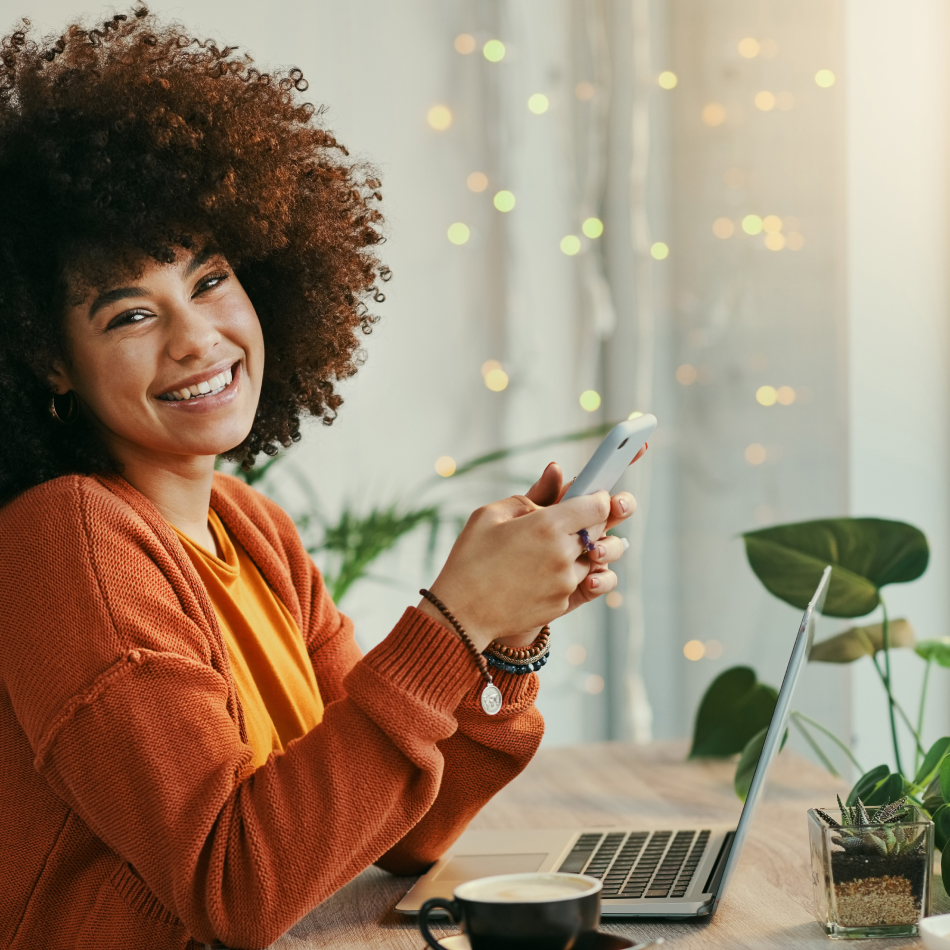 Mujer sonriendo mientras consulta su teléfono móvil